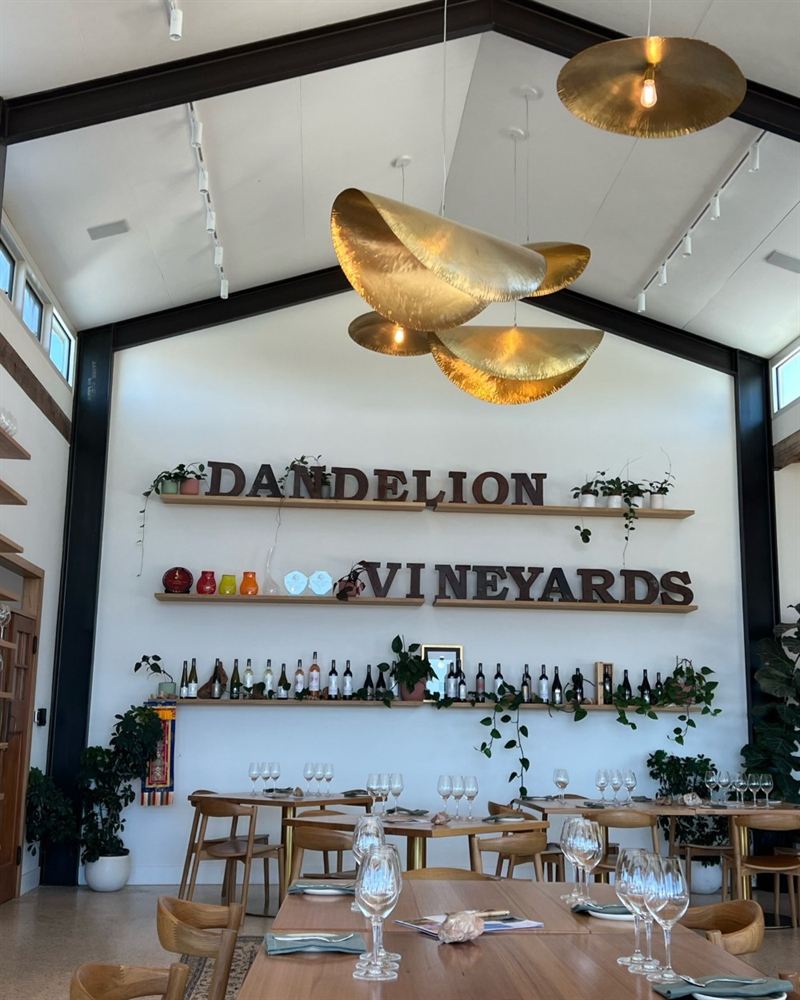 a big room with gold dandelion chandelier and coffee tables