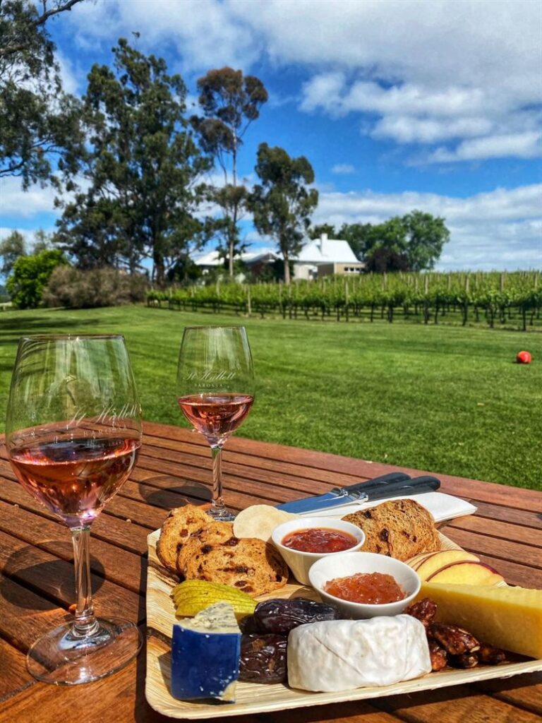 cheeseboard and rose on a teak decking at a winery